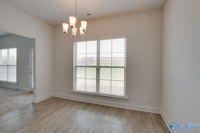 214 Tybee Dr, Madison, AL 35756 - empty room with baseboards, visible vents, wood finished floors, and a notable chandelier