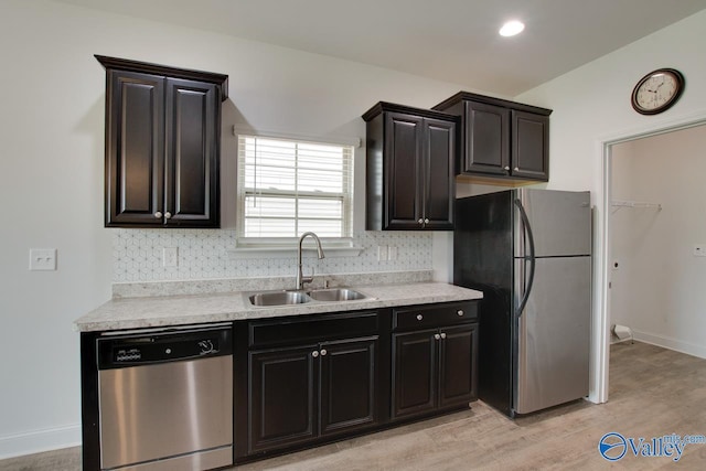 214 Tybee Dr, Madison, AL 35756 - kitchen featuring backsplash, appliances with stainless steel finishes, a sink, light countertops, and light wood finished floors
