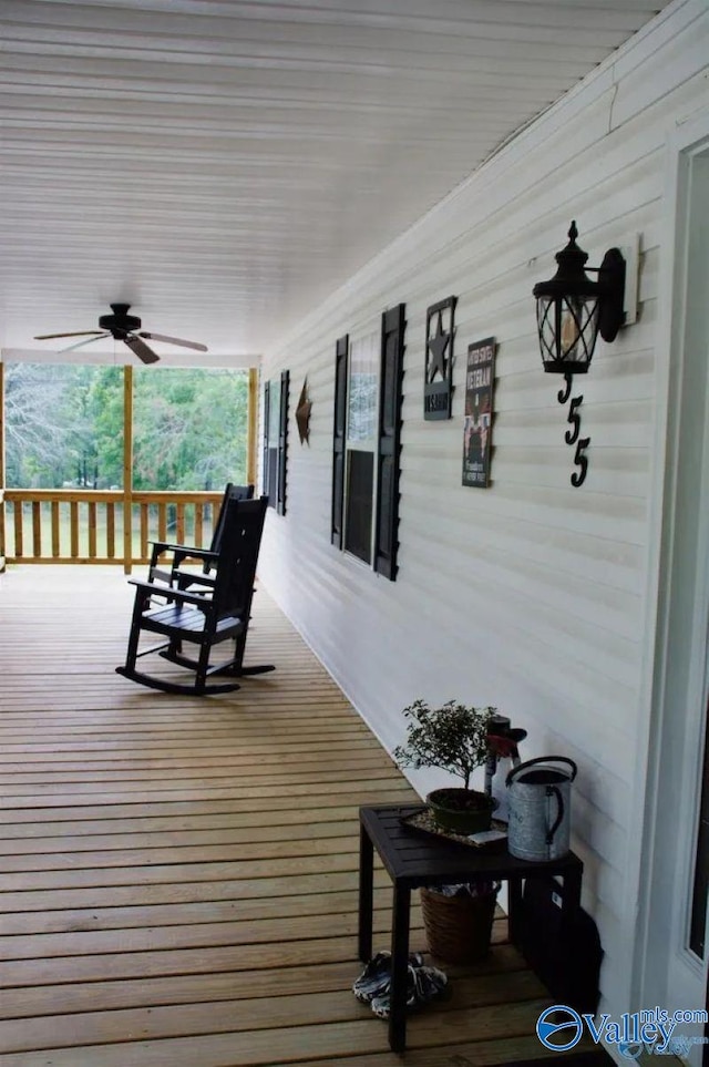 wooden terrace featuring covered porch and ceiling fan