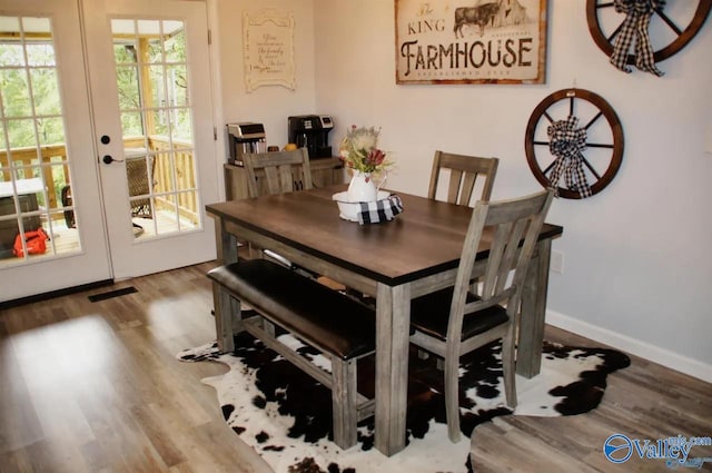 dining space featuring french doors and light hardwood / wood-style flooring