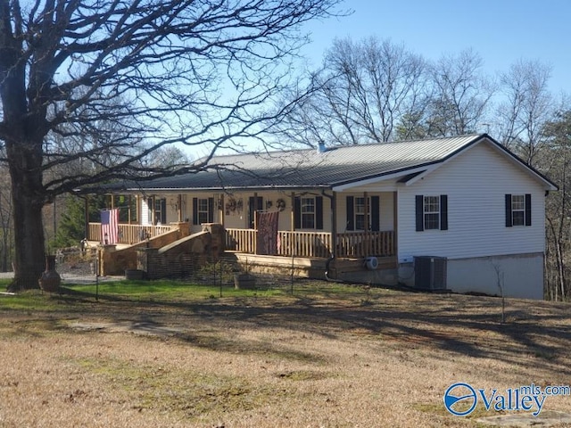 ranch-style home featuring covered porch, a front lawn, and central air condition unit