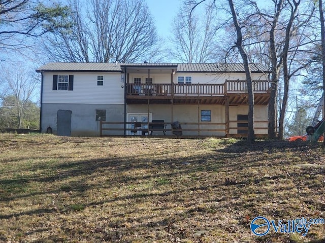 rear view of property with a yard and a wooden deck