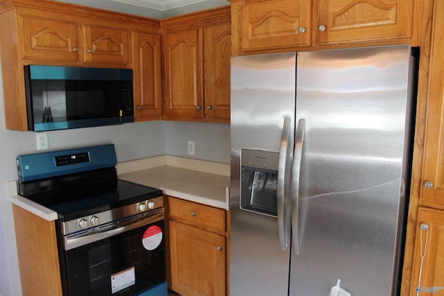 kitchen featuring brown cabinetry, stainless steel appliances, and light countertops