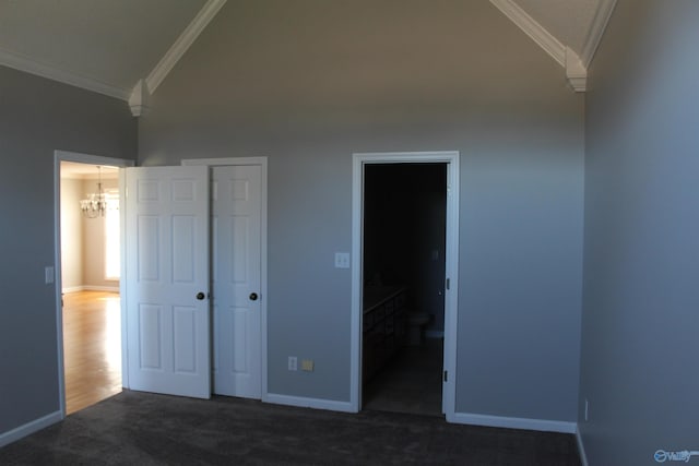 unfurnished bedroom featuring baseboards, ornamental molding, dark colored carpet, and a closet