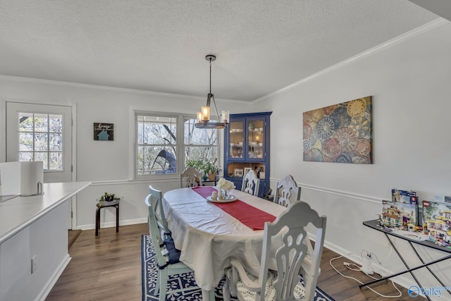 dining area featuring ornamental molding, a textured ceiling, and a notable chandelier