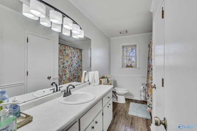 bathroom with crown molding, vanity, toilet, and hardwood / wood-style floors