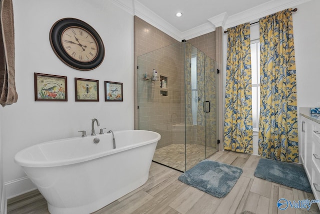 bathroom with vanity, plus walk in shower, hardwood / wood-style flooring, and crown molding