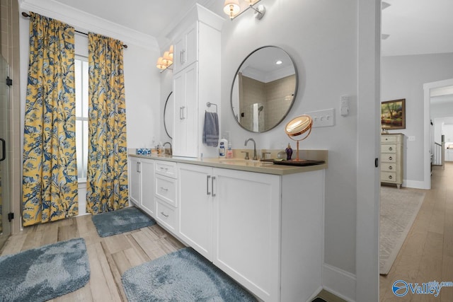 bathroom featuring wood-type flooring, vanity, vaulted ceiling, and ornamental molding