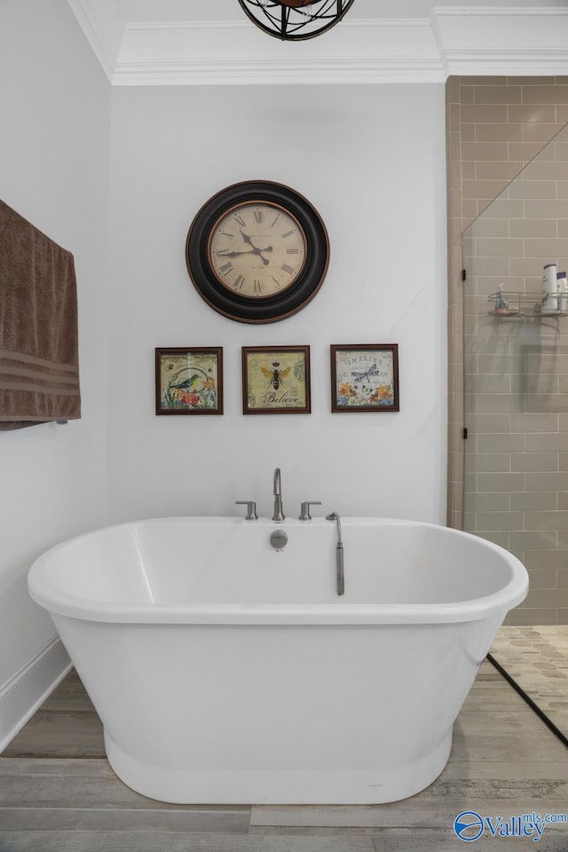 bathroom featuring ornamental molding, wood-type flooring, and a washtub