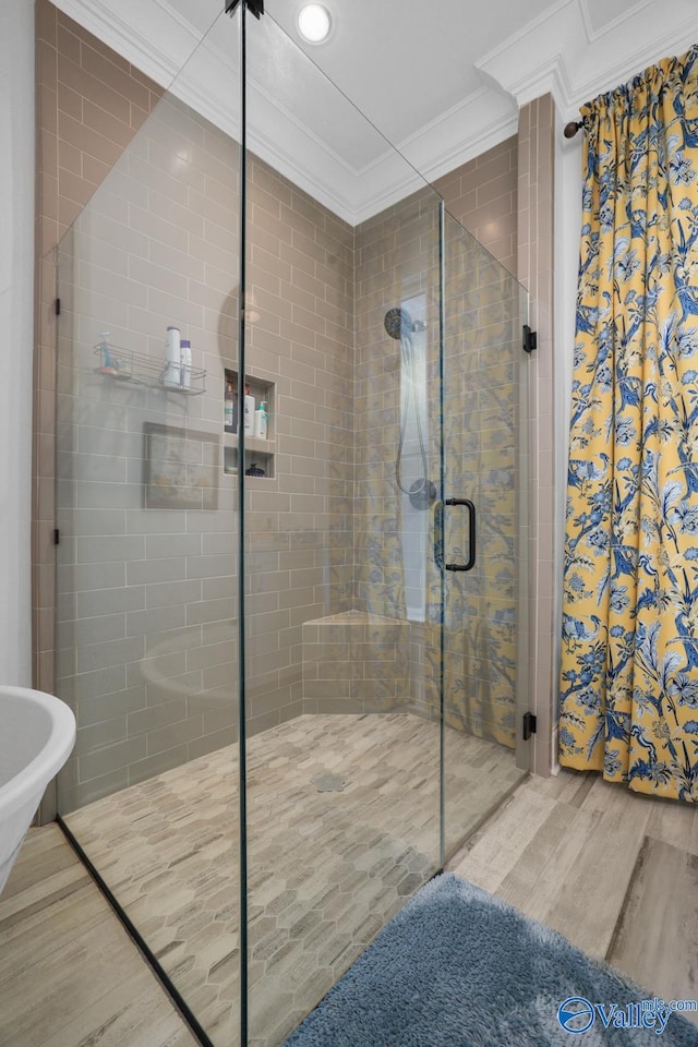 bathroom with an enclosed shower, hardwood / wood-style floors, and crown molding