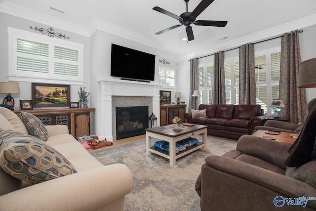 living room with crown molding, ceiling fan, and a fireplace