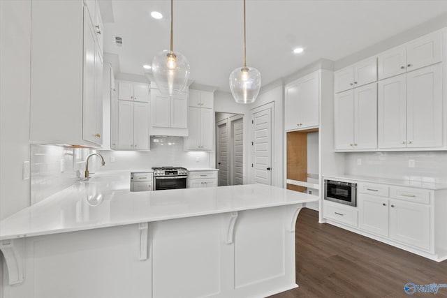 kitchen with decorative light fixtures, sink, appliances with stainless steel finishes, and white cabinets