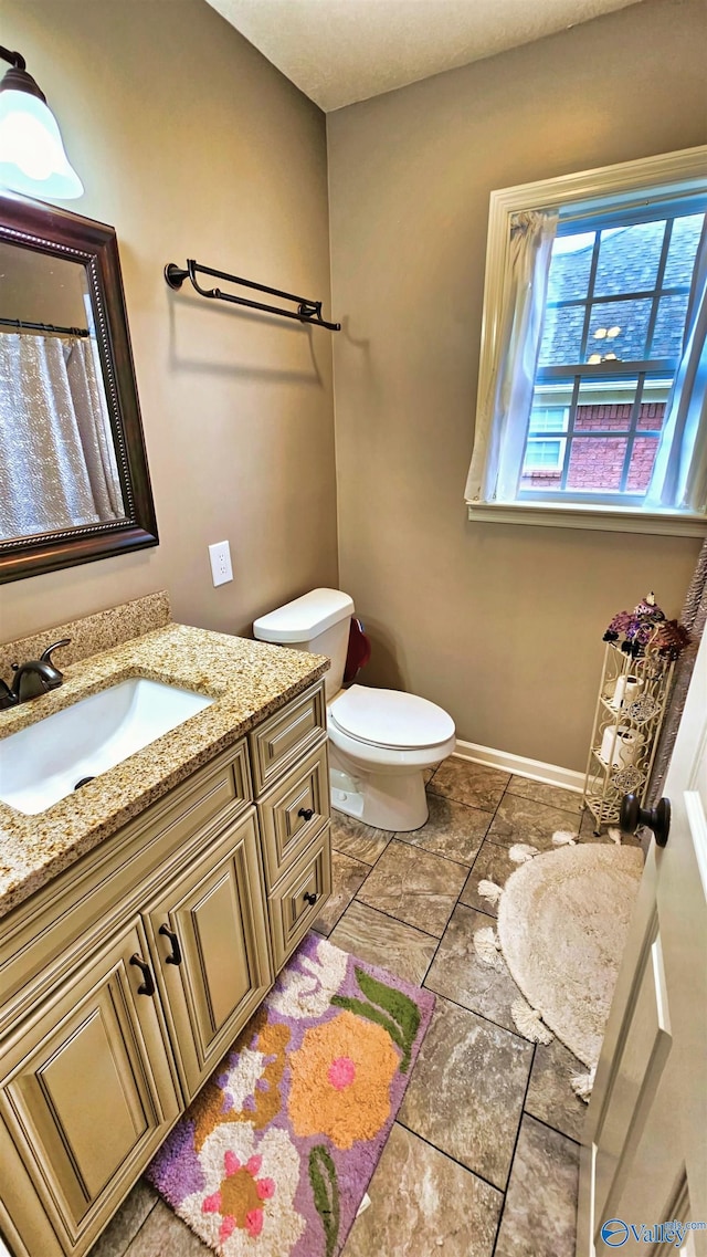 403 E Charlotte Ave, Scottsboro, AL 35768 - full bathroom featuring vanity, baseboards, and toilet