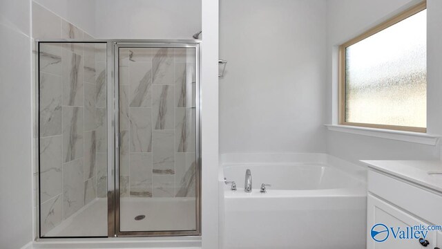 bathroom featuring shower with separate bathtub and vanity