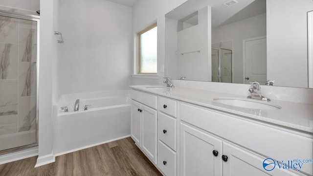 bathroom with vanity, shower with separate bathtub, and hardwood / wood-style floors