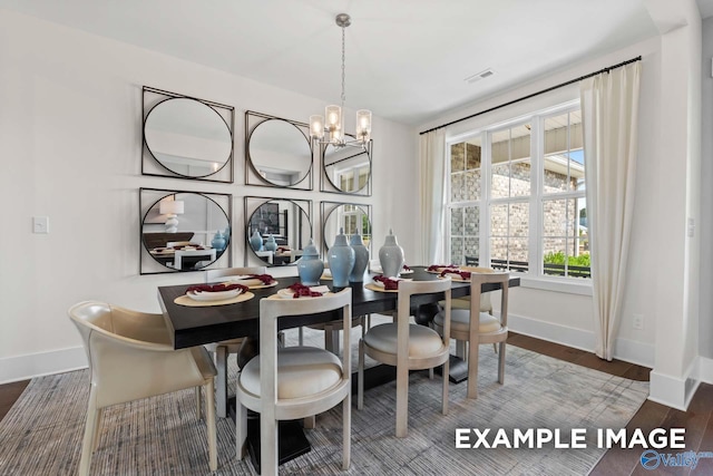 dining room featuring baseboards, visible vents, an inviting chandelier, and wood finished floors