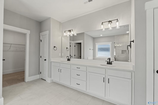 full bath featuring visible vents, a sink, a shower stall, and double vanity