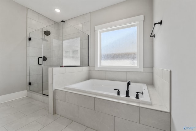 bathroom featuring a stall shower, tile patterned flooring, and a garden tub