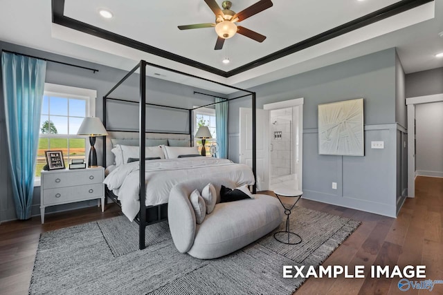 bedroom with a tray ceiling, recessed lighting, wood finished floors, and baseboards