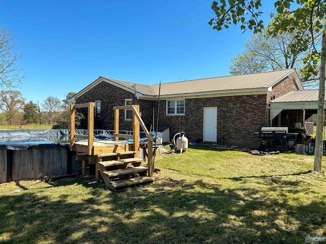 rear view of property featuring a deck and a yard