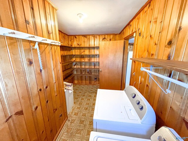 washroom with tile patterned flooring, independent washer and dryer, and wooden walls