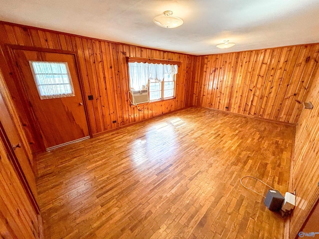 foyer entrance featuring wood-type flooring, wooden walls, and cooling unit