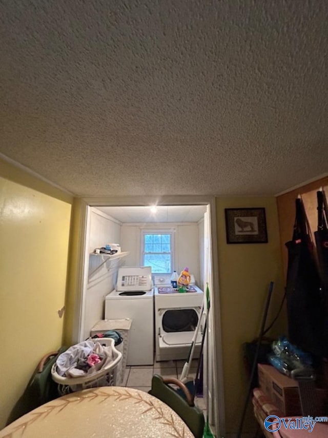 laundry area with separate washer and dryer and a textured ceiling