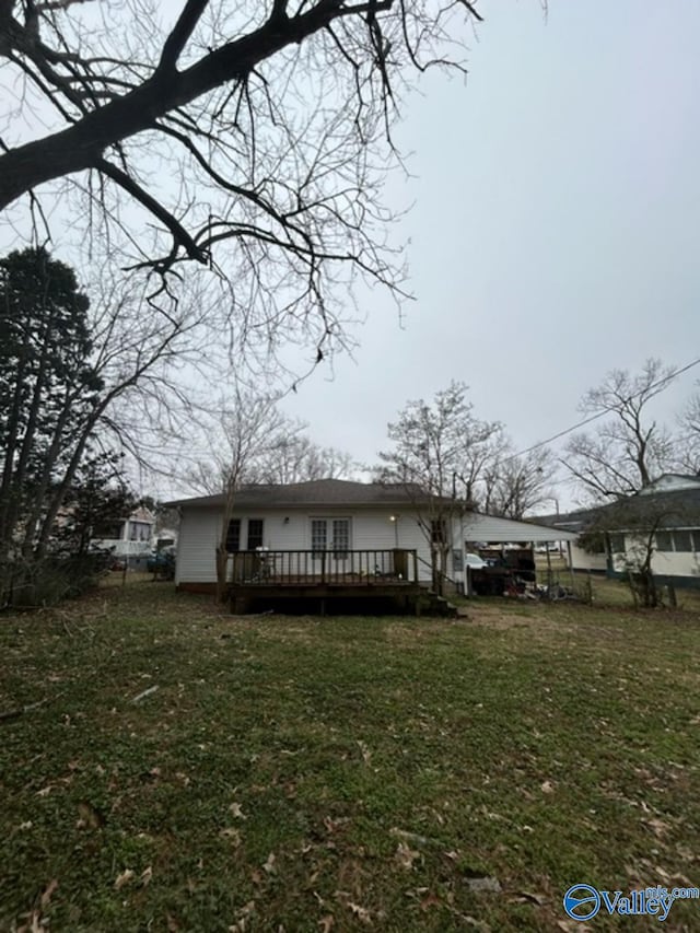 back of house with a wooden deck and a lawn