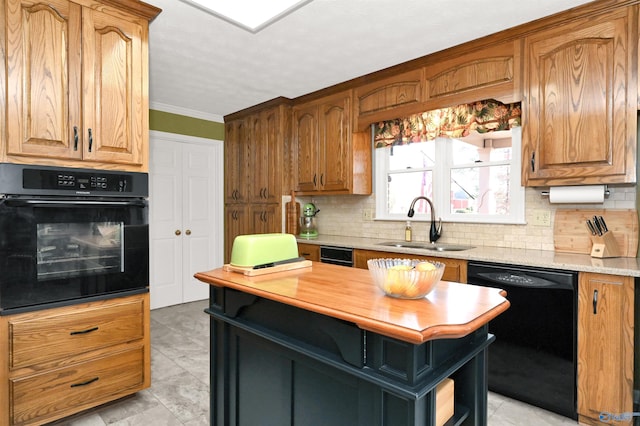 kitchen featuring backsplash, light stone counters, crown molding, sink, and black appliances