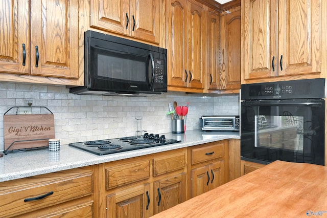 kitchen with wood counters, tasteful backsplash, and black appliances