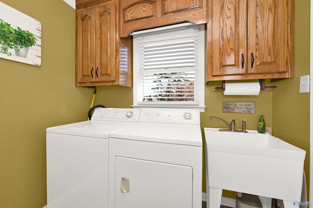 laundry room with cabinets, independent washer and dryer, and sink