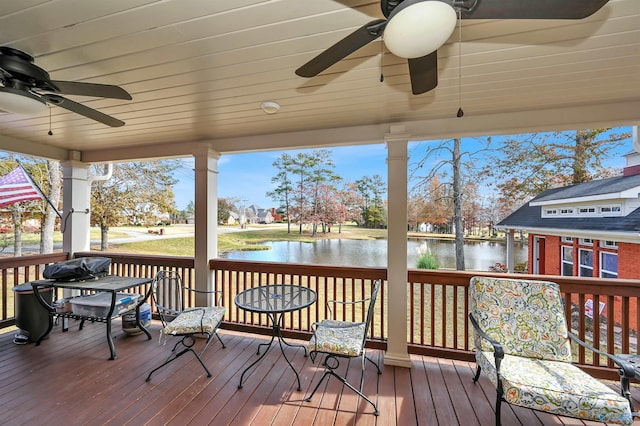 wooden terrace with a water view and ceiling fan