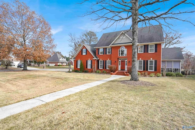 colonial-style house featuring a front yard