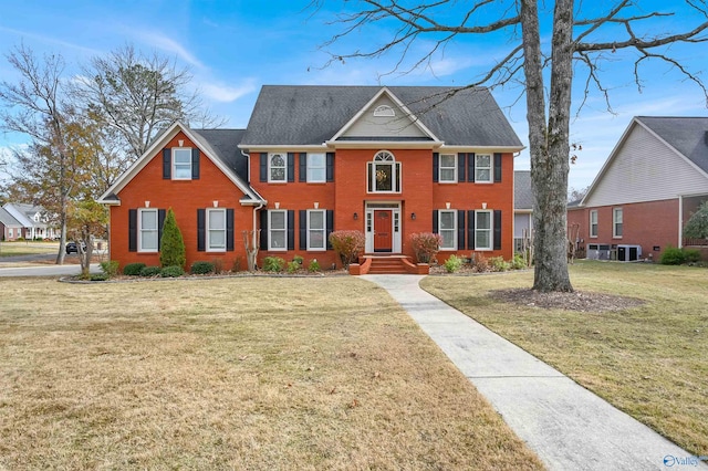 colonial house with central air condition unit and a front lawn