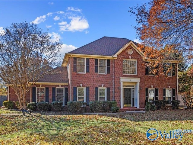 colonial inspired home with a front lawn