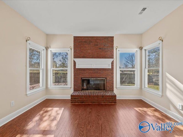 unfurnished living room with a fireplace and dark hardwood / wood-style floors