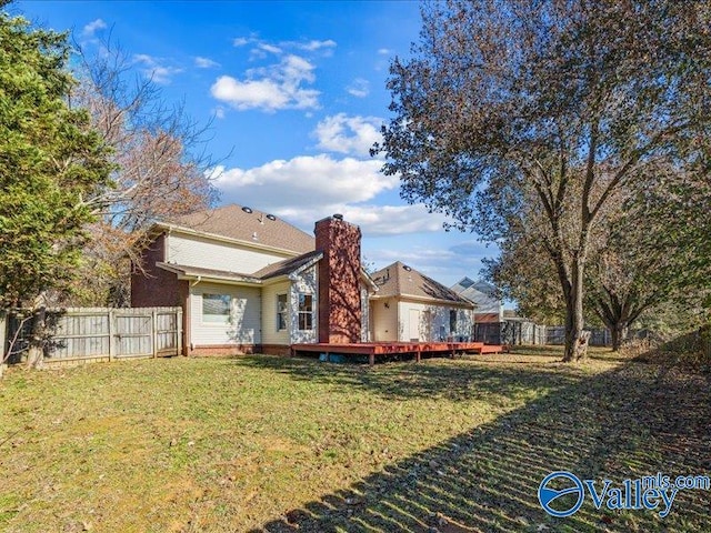 back of house with a wooden deck and a yard