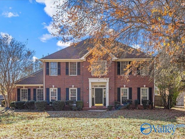 colonial inspired home with a front lawn