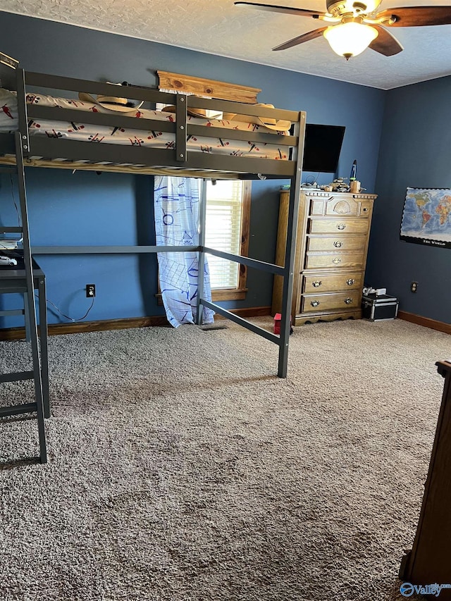 unfurnished bedroom featuring a ceiling fan, baseboards, a textured ceiling, and carpet flooring