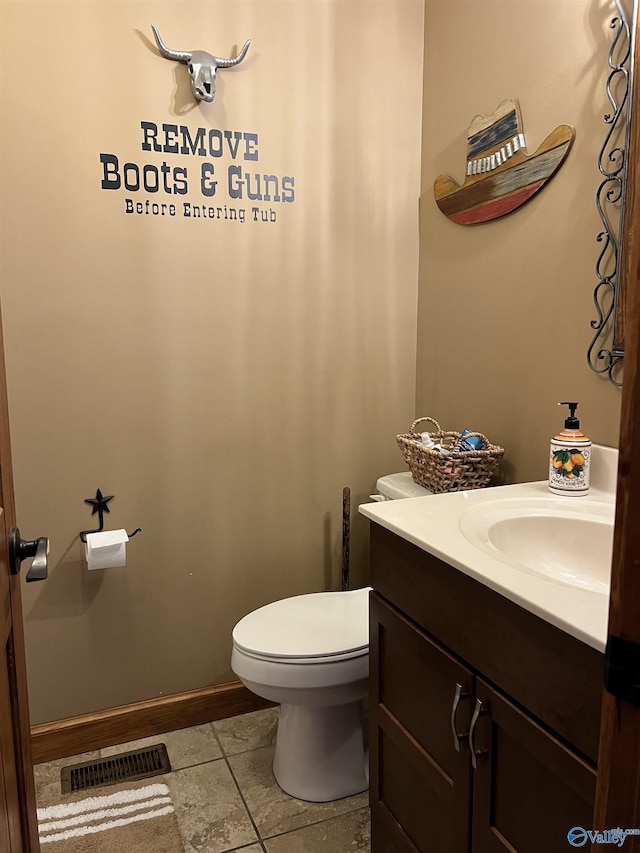 half bath with visible vents, toilet, vanity, and baseboards