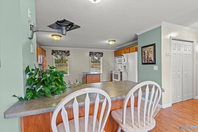 kitchen with white appliances, kitchen peninsula, a textured ceiling, and light wood-type flooring