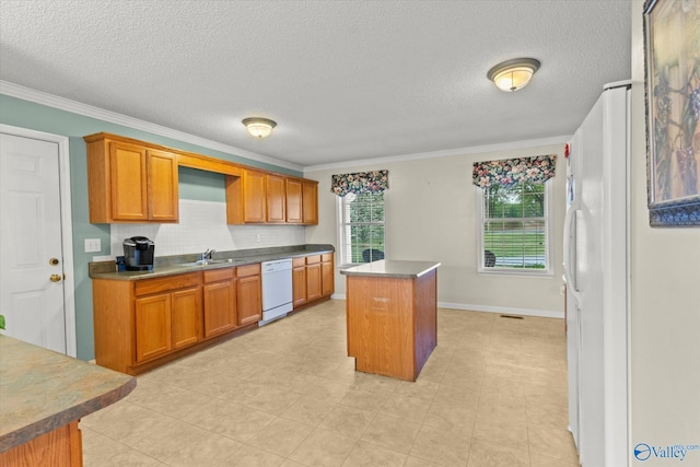 kitchen featuring dishwasher, a center island, sink, and ornamental molding