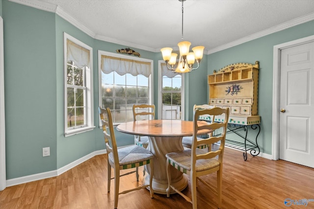 dining space with crown molding, hardwood / wood-style floors, a textured ceiling, and a notable chandelier