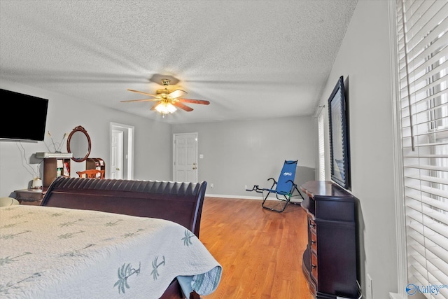 bedroom featuring hardwood / wood-style flooring, ceiling fan, and a textured ceiling