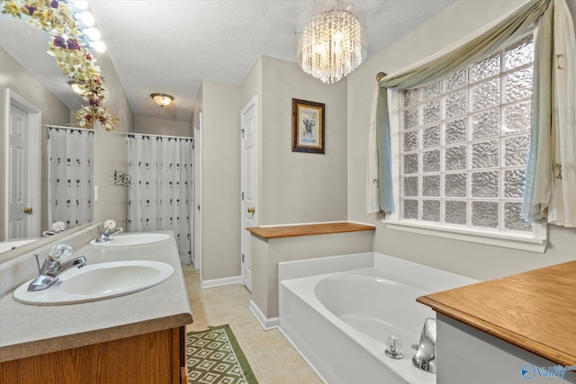 bathroom with an inviting chandelier, vanity, shower with separate bathtub, and a textured ceiling