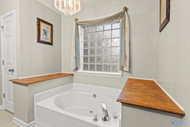 bathroom featuring a chandelier and a tub to relax in