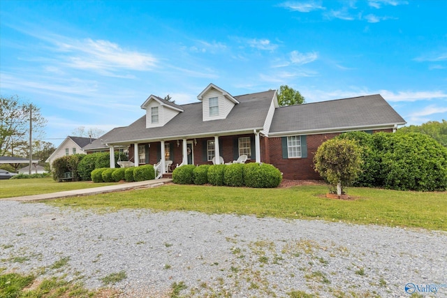 cape cod home featuring a front lawn and covered porch