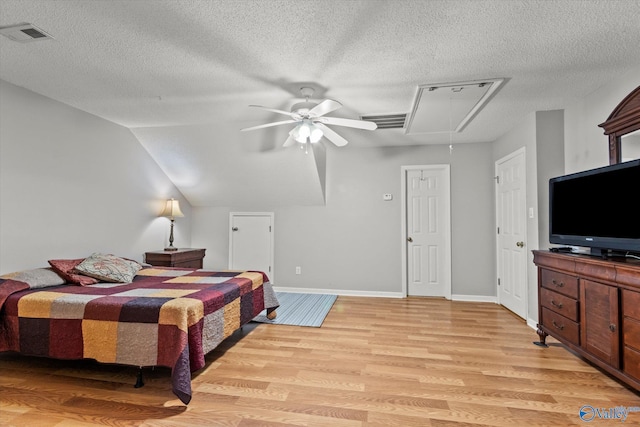 bedroom featuring lofted ceiling, ceiling fan, light hardwood / wood-style flooring, and a textured ceiling