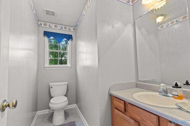 bathroom featuring vanity, tile patterned floors, toilet, and a textured ceiling