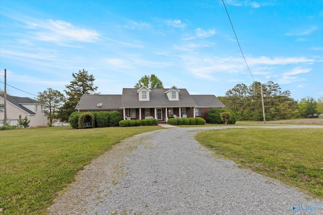 cape cod house featuring covered porch and a front lawn